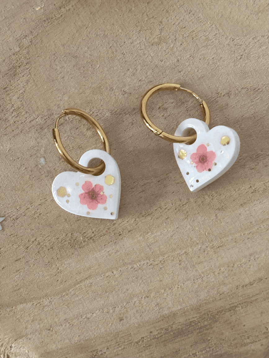 Créoles dorées avec pendentifs cœurs blancs décorés d'une fleur rose et de paillettes